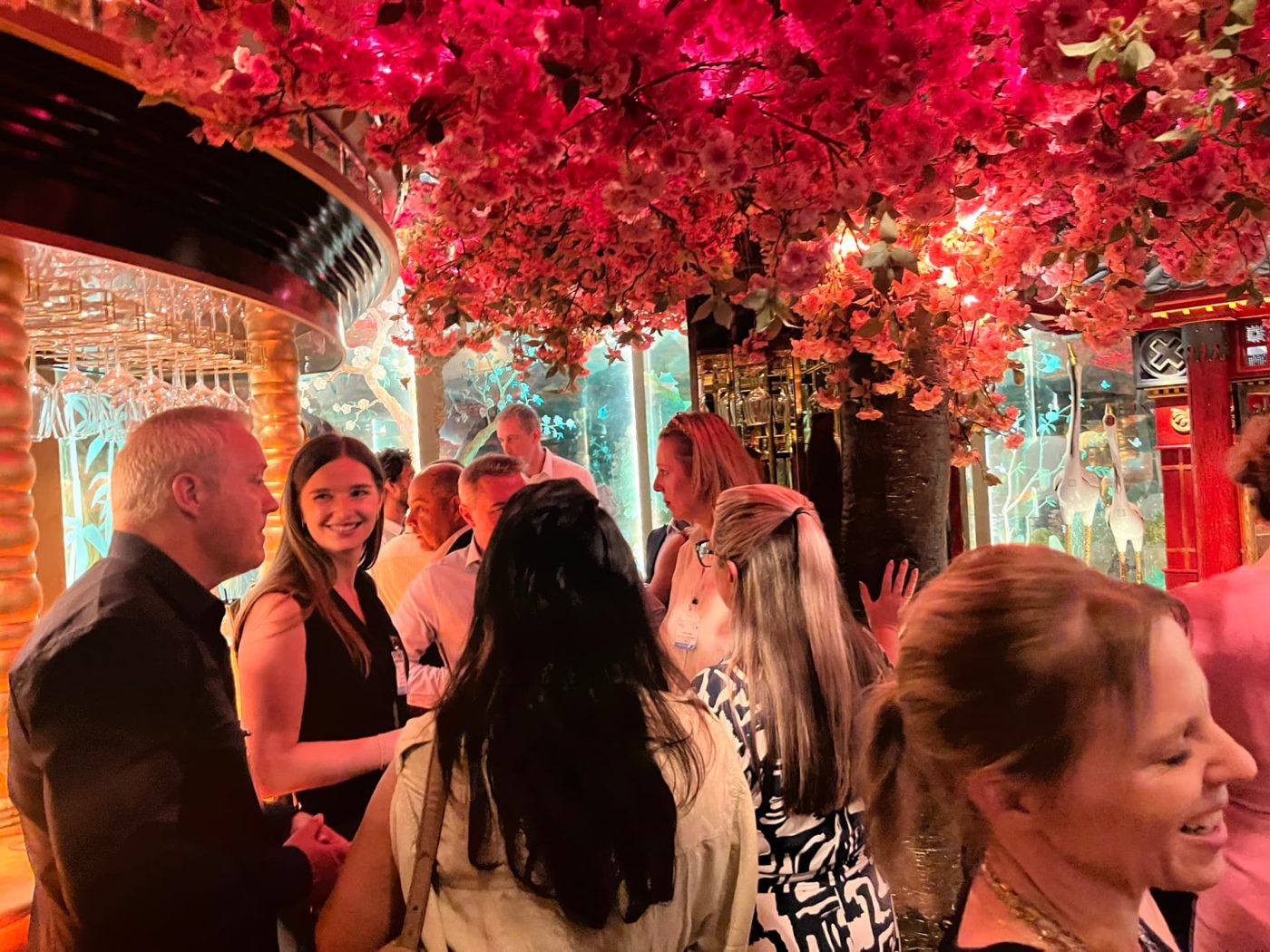 Senior guests networking under blossom at an ELN event